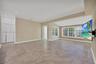 Neutral tile flooring, recessed lighting, crown molding, multi-pane windows, and white louvered closet doors