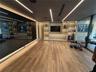 Slatted wood ceiling with recessed linear lighting, full-height wall mirror, wood-finish flooring, and built-in display shelving featuring integrated 