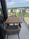 Private balcony with tile flooring and a glass-paneled metal railing