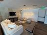 Recessed lighting, wood-finish flooring, and an accent wall featuring textured wallcovering