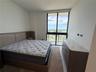 Floor-to-ceiling windows, tile flooring, and exterior balcony access