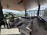 Covered rooftop terrace featuring natural wood-finish plank ceilings, recessed lighting, ceiling fans, stone flooring, and metal railings