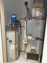 Mechanical utility closet containing a ClimateMaster geothermal heat pump, a Bradford White electric water heater, and a thermal expansion tank with i