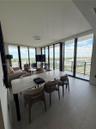 Floor-to-ceiling windows with panoramic exterior exposure, tile flooring, and access to a private balcony