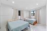 Neutral wall tones, polished stone-finish flooring, recessed ceiling lighting, and black-framed windows