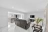 Large-format tile flooring, recessed ceiling lighting, and built-in kitchen peninsula with a stone-finish countertop