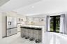 Kitchen featuring a center island with quartz countertop, stainless steel appliances, flat-panel cabinetry, recessed lighting, and large glass-panel d