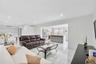 Open floor plan featuring recessed lighting, polished stone-finish tile flooring, and a kitchen island with stone-finish countertop