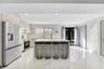 Kitchen featuring white cabinetry, a center island with a stone-finish countertop, stainless steel appliances, recessed lighting, and large-format til