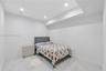 Neutral-toned interior space featuring light-colored stone-finish tile flooring, recessed ceiling lighting, and a recessed ceiling architectural detai