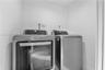 Dedicated laundry alcove equipped with stainless steel front-loading washer and dryer units