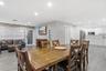 Open-concept living space featuring wood-finish flooring, recessed lighting, exposed brick accent wall, and a kitchen with white cabinetry and stainle