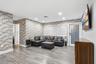 Interior featuring brick veneer accent walls, wood-finish flooring, recessed lighting, and a frosted glass exterior door