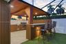 Covered outdoor kitchen featuring vertical slat siding, recessed ceiling lighting, a stone-finish bar counter, and built-in stainless steel appliances