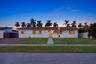 Single-story residence featuring a smooth stucco exterior, a tiled roof, a concrete walkway, and a paved driveway