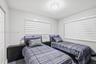 Neutral wall palette with wood-finish flooring, dual windows equipped with horizontal roller shades, and a flush-mount circular ceiling light fixture
