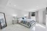 Large-format polished stone flooring, recessed ceiling lighting, and a single window with dark-toned framing