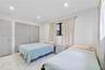 Bedroom featuring large-format light-toned tile flooring, recessed ceiling lighting, and built-in shaker-style closet cabinetry with neutral hardware