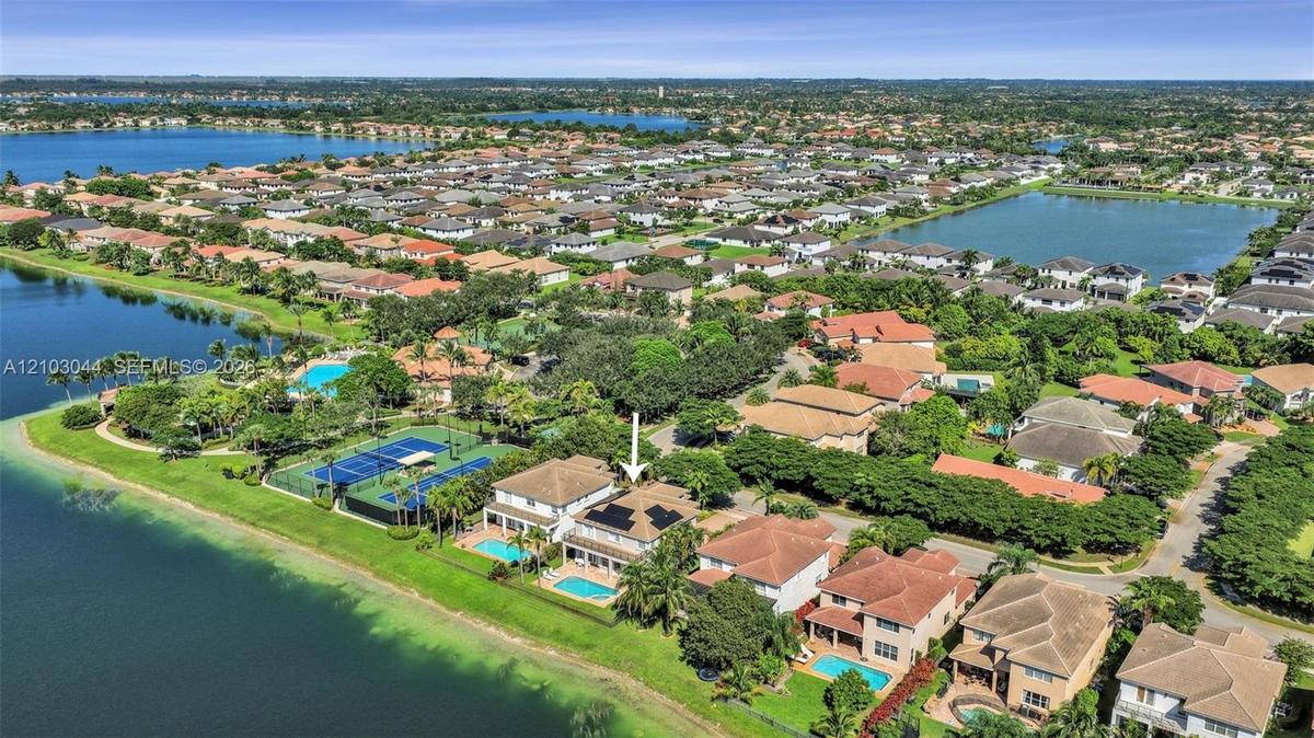 Waterfront property featuring a private swimming pool, tile roof, and solar panels