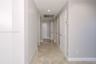Hallway featuring diagonal-set stone-finish flooring, recessed lighting, and multiple interior paneled doors with metal hardware