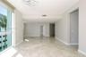 Floor-to-ceiling windows, polished stone tile flooring, modern circular chandelier, and recessed lighting
