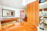 Custom vanity featuring a polished stone countertop with an integrated basin, stainless steel under-counter appliances, vertical wood-panel wall featu
