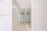 Hallway featuring stone tile flooring, recessed ceiling lighting, and an expansive wall-mounted mirror