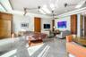 Common area featuring stone tile flooring, textured wall finishes, wood-paneled accent walls, recessed ceiling lighting, and ceiling-mounted fans