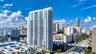 High-rise architectural structure featuring glass-paneled balconies and a multi-level parking facility