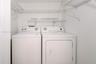 Laundry area featuring multi-level wire shelving and side-by-side appliances