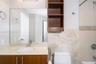 Bathroom featuring a vanity with stone-finish countertop, integrated oval sink, and wood-finish cabinetry