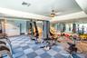 Multi-purpose room featuring a dual-toned checkerboard tile floor, mirrored wall accents, tray ceiling, and dual integrated ceiling fans