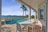 Covered patio with stone-tile flooring featuring a built-in swimming pool, integrated spa, and metal perimeter fencing