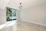 Floor-to-ceiling windows, polished stone flooring, and contemporary sculptural chandelier