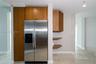 Stainless steel side-by-side refrigerator, wood-finish cabinetry with vertical hardware, custom built-in shelving, and tile flooring