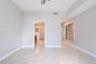 Interior room featuring neutral-toned stone-finish flooring, a large wall-mounted mirror, and a geometric flush-mount light fixture