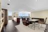 Open-concept interior featuring wood-finish flooring, floor-to-ceiling windows, recessed lighting, and kitchen island with integrated cabinetry
