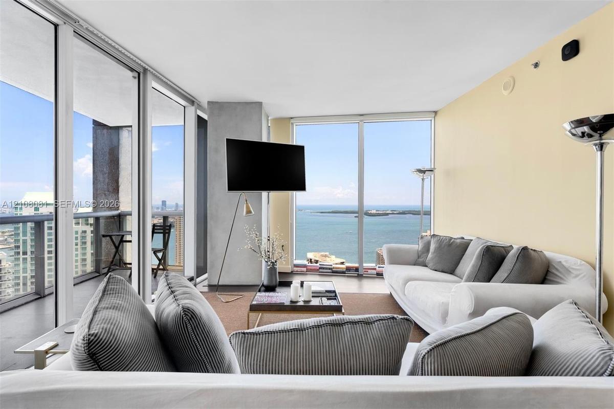 Floor-to-ceiling glass windows, private balcony, and polished concrete flooring