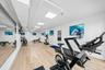 Spacious interior featuring wood-finish flooring, recessed lighting, and expansive wall-mounted mirrors