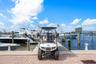 Paved concrete pier featuring deep-water boat slips and wood pilings