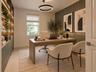 Built-in cabinetry with integrated LED lighting, vertical paneled accent wall, modern circular pendant fixture, and single-hung window with roller sha