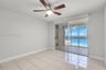 Interior space featuring large-format ceramic tile flooring, ceiling fan with integrated lighting, and full-height sliding glass doors opening to a ti