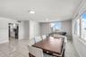 Open-concept interior featuring large-format ceramic tile flooring, neutral walls, recessed ceiling lighting, and expansive windows