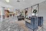 Expansive lobby featuring polished stone flooring in a herringbone pattern, floor-to-ceiling decorative mirrors, recessed lighting, crystal chandelier