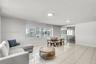 Open concept interior featuring large-format tile flooring, recessed LED lighting, expansive horizontal windows, and sliding glass balcony doors