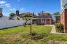 Fenced backyard featuring a manicured lawn, a concrete patio, and a pergola structure
