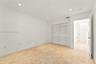 Neutral-toned stone flooring, recessed ceiling lighting, and a multi-panel closet with louvered doors