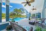 Covered lanai featuring dual ceiling fans, concrete decking, and a swimming pool with an integrated spa