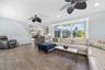 Living area featuring wood-finish flooring, recessed lighting, and dual ceiling fans with matte black finishes, complemented by a large multi-pane win