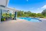 Covered patio with dual ceiling fans, concrete decking, in-ground swimming pool, and an integrated spa
